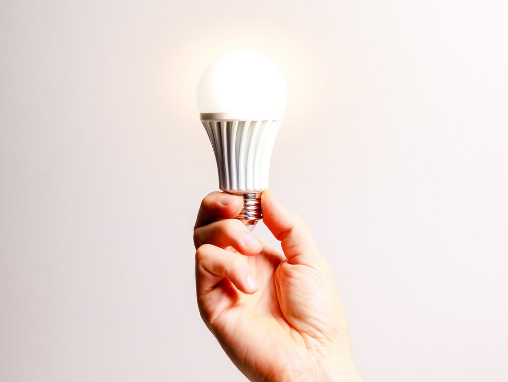 image of a hand holding a LED lightbulb