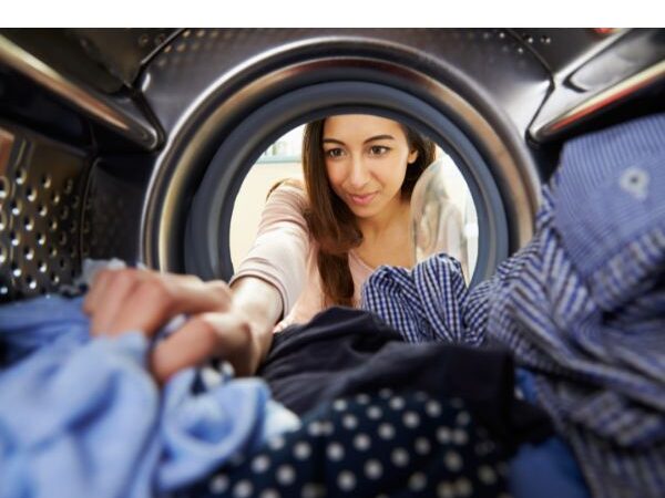 image of a woman filling a washing machine