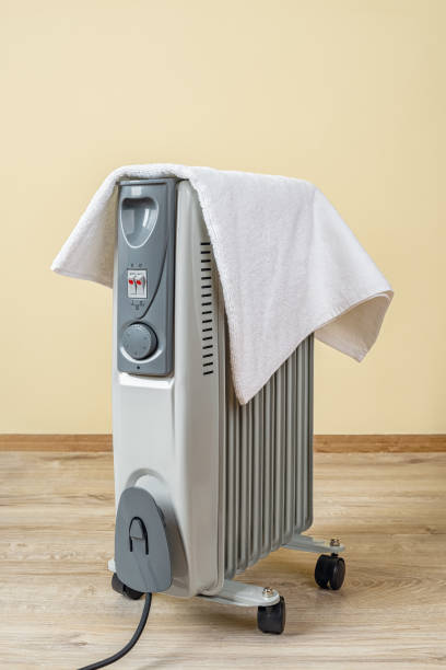 oil filled electric heater covered with a towel in a room terry towel dries on the portable
