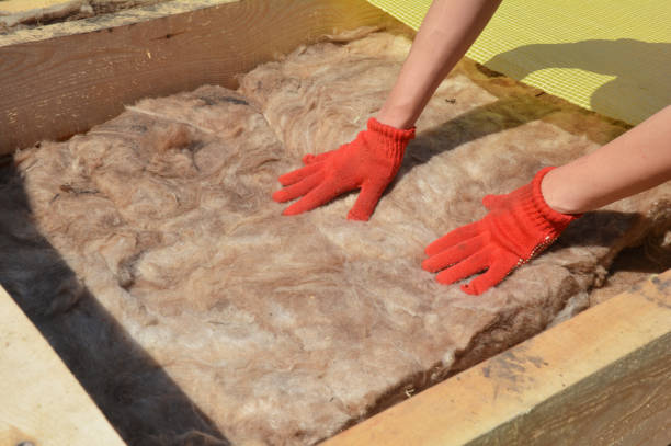 a builder in protective gloves is insulating the roof with a glass wood thermal insulation